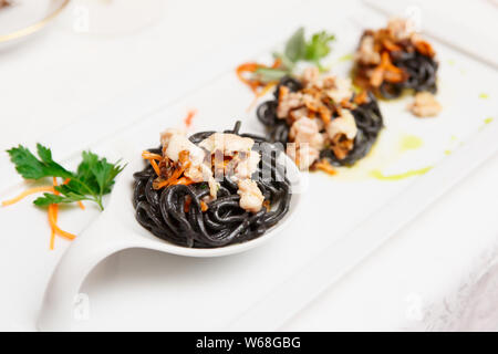 Black pasta with seafood, gourmet dish, close-up