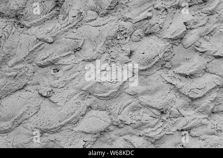 Rough cement plaster on the wall. Facade plaster background. Single-ply monolithic plaster decorative background. Single layer scraped cement plaster