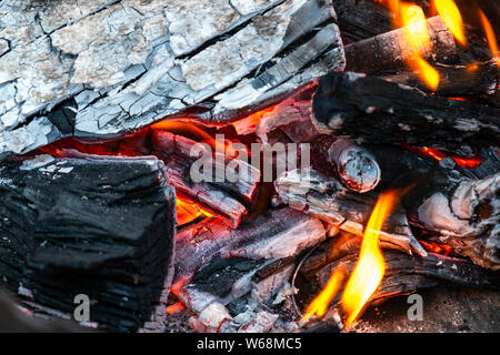 Closeup of burning and smoldering firewood. Close-up of Burning coal. Glowing embers smoldering in the fireplace. Burning log of wood close-up as abst Stock Photo