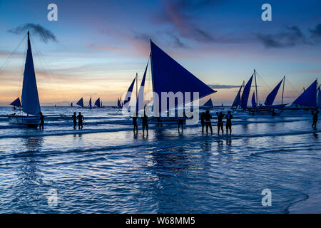 Traditional Paraws (Sailing Boats) On A Sunset Cruise off White Beach, Boracay, Aklan Province, The Philippines. Stock Photo