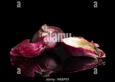 Group of one whole one half one piece of stale red onion isolated on black glass Stock Photo