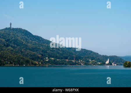 WORTHERSEE, AUSTRIA - AUGUST 08, 2018:  Worthersee view at turquoise water of lake in summer mountains in distance. Tourists enjoying summer vacations Stock Photo