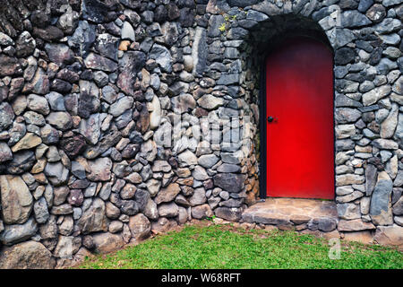 The red door near Hana is part of this volcanic rock fence line on Hawaii’s Island of Maui. Stock Photo