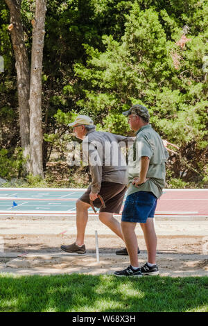 Two senior men playing pitching horseshoes in a Sun City, Texas adult retirement community. Stock Photo