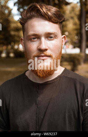 Portrait of an attractive redhead man with a beard. Close-up of a smiling male face. Stock Photo