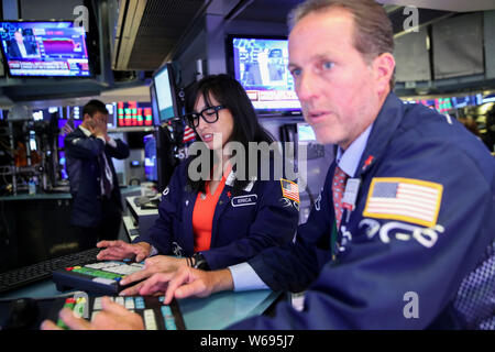 New York, USA. 31st July, 2019. Traders work at the New York Stock Exchange in New York, the United States, July 31, 2019. U.S. stocks ended lower on Wednesday. The Dow decreased 1.23 percent to 26,864.27, the S&P 500 fell 1.09 percent to 2,980.38, and the Nasdaq was down 1.19 percent to 8,175.42. Credit: Wang Ying/Xinhua/Alamy Live News Stock Photo