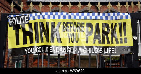 A 'Think Before You Park' banner on a primary school gate in Stockport, Greater Manchester, uk Stock Photo