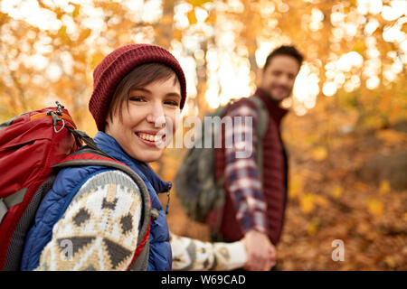 Attractive caucasian couple hiking through the forest in the fall in Canada Stock Photo