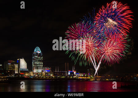 Fireworks launch from a barge in the Ohio River in Cincinnati, Ohio, USA, against the Cincinnati cityscape, including Great American Ball Park. Stock Photo