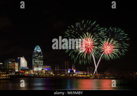 Fireworks launch from a barge in the Ohio River in Cincinnati, Ohio, USA, against the Cincinnati cityscape, including Great American Ball Park. Stock Photo