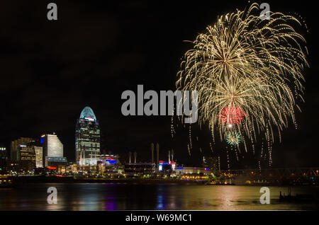 Fireworks launch from a barge in the Ohio River in Cincinnati, Ohio, USA, against the Cincinnati cityscape, including Great American Ball Park. Stock Photo