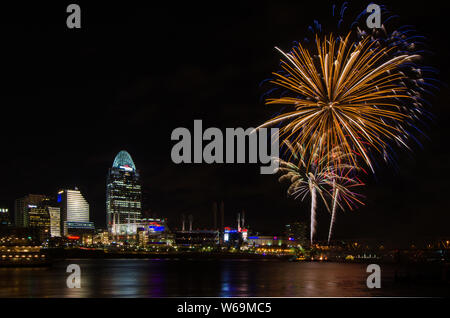 Fireworks launch from a barge in the Ohio River in Cincinnati, Ohio, USA, against the Cincinnati cityscape, including Great American Ball Park. Stock Photo