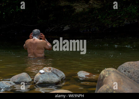 A man taking a bath in a river near the town of Togui, Boyaca, in the temperate land of the Andean mountains of Colombia. Stock Photo