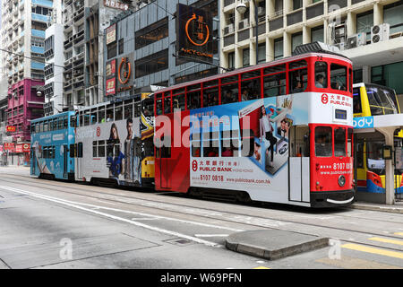 Three double-decker trams on a tram stop in Sai Wan district, Hong Kong Stock Photo