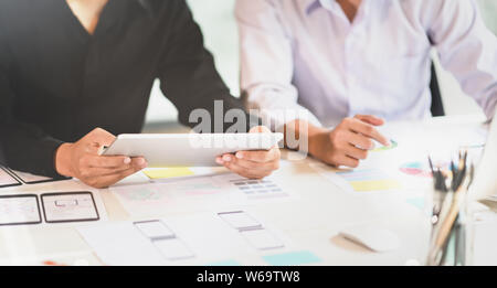 Professional UI UX designer team picking up the ideas about smartphone applications while using tablet Stock Photo