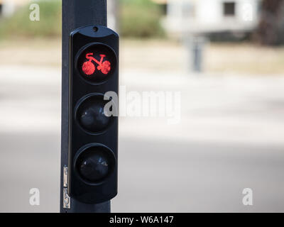 Bicycle traffic light from France, obeying by European road standards, indicating red light for cyclists and all the bike vehicles located on a bicycl Stock Photo