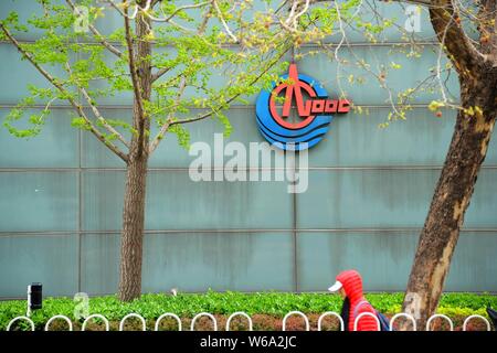 --FILE--A pedestrian walks past the headquarters of China National Offshore Oil Corporation (CNOOC) in Beijing, China, 4 April 2018.   China's has beg Stock Photo