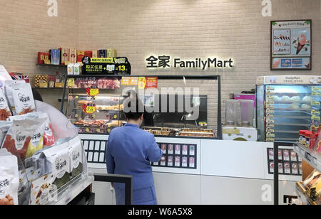 --FILE--A customer shops at a Family Mart convenience store in Shanghai, China, 4 September 2018.   Japan's convenience stores are aggressively penetr Stock Photo