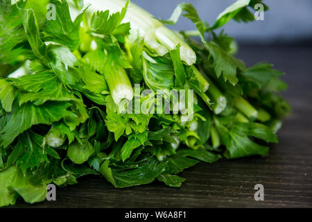 Fresh bunch of celery bought from the local supermarket for a delicious winter stew in the slow cooker. Vibrant green leaves, pale green stalks Stock Photo