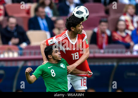 Yuri Zhirkov of Russia, right, heads the ball against Yahya Al-Shehri of Saudi Arabia in their Group A match during the 2018 FIFA World Cup in Moscow, Stock Photo