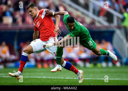 Roman Zobnin of Russia, left, challenges Salem Al-Dawsari of Saudi Arabia in their Group A match during the 2018 FIFA World Cup in Moscow, Russia, 14 Stock Photo