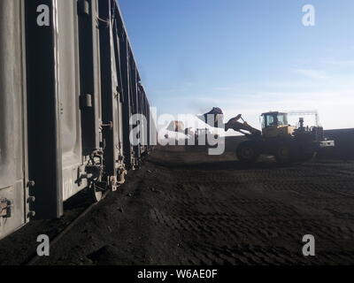 --FILE--Chinese workers drive wheel loaders to load a freight train with coal in Alxa League, north China's Inner Mongolia Autonomous Region, 22 Novem Stock Photo