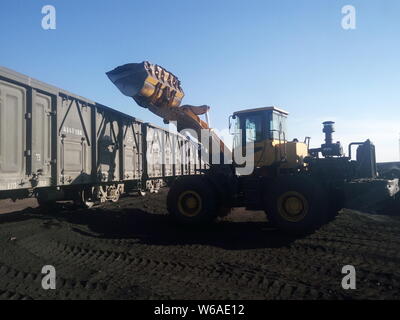 --FILE--Chinese workers drive wheel loaders to load a freight train with coal in Alxa League, north China's Inner Mongolia Autonomous Region, 22 Novem Stock Photo