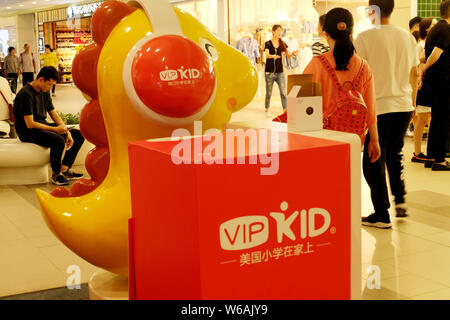 --FILE--Customers walk past the stand of China's largest online education startup VIPKID at a shopping mall in Shanghai, China, 10 June 2018.   VIPKID Stock Photo