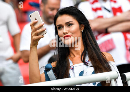 A hot female Polish fan wearing a red and white jersey watches the Group H match between Poland and Senegal during the 2018 FIFA World Cup in Moscow, Stock Photo