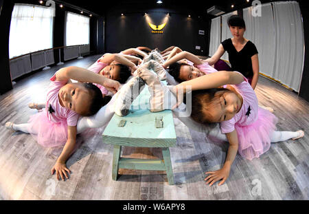 A Chinese teacher instructs young girls to stretch their legs and bend their bodies to learn dancing skills at a training center in Bozhou city, east Stock Photo