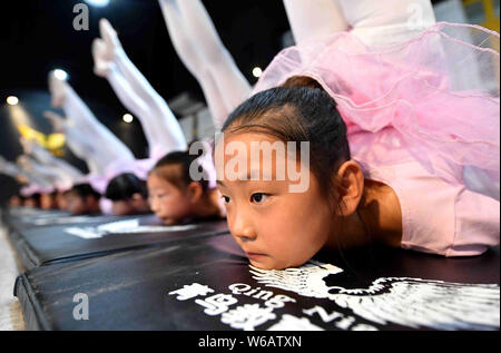 Young Chinese girls bend their bodies to learn dancing skills at a training center in Bozhou city, east China's Anhui province, 24 June 2018.   Many C Stock Photo