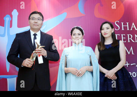 Batbayar Chogsom, left, director of 'Out of Paradise', wins the Best Feature Film award at the awarding ceremony of the 21st Golden Goblet Awards duri Stock Photo