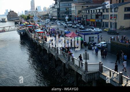 Tourists look far into the distance over Sinuiju of North Korea on the other side of Yalu River, also called the Amrok River or Amnok River, on the bo Stock Photo