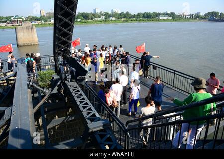 Tourists look far into the distance over Sinuiju of North Korea on the other side of Yalu River, also called the Amrok River or Amnok River, on the bo Stock Photo