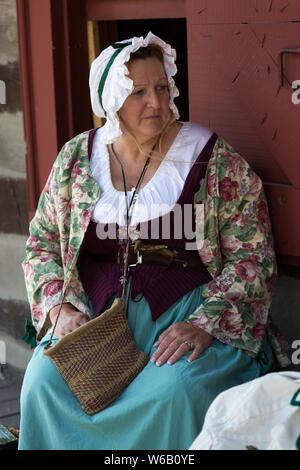 A reenactress in period clothing portrays an 18th century woman during an event at Historic Old Fort Wayne in Fort Wayne, Indiana, USA. Stock Photo