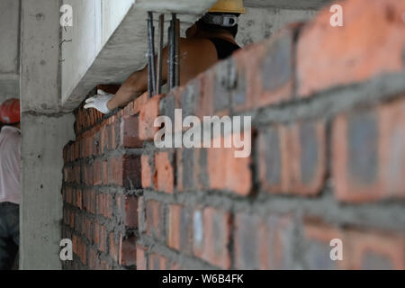 plasterer making up a brick wall with cement Stock Photo