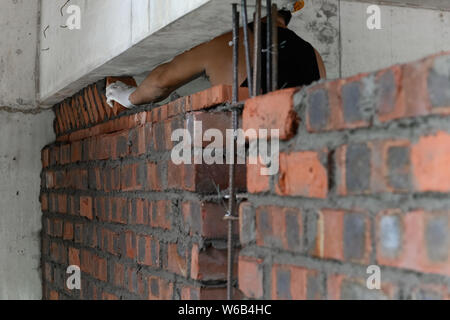 plasterer making up a brick wall with cement Stock Photo