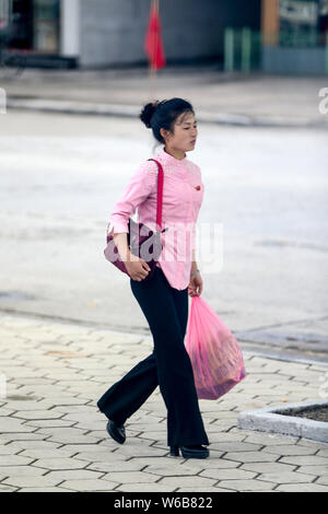 --FILE--A North Korean woman wearing high heels walks on the street in Pyongyang, North Korea, 28 August 2016. Stock Photo