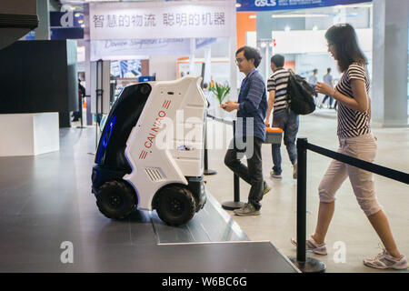 --FILE--Visitors look at a delivery robot of Cainiao Network, the delivery arm of Chinese e-commerce giant Alibaba Group, during an expo in Hangzhou c Stock Photo
