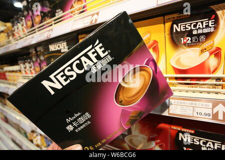 --FILE--A customer shops for a carton of Nescafe coffee of Nestle at a supermarket in Xuchang city, central China's Henan province, 16 November 2014. Stock Photo