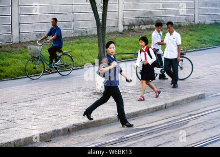 --FILE--A North Korean woman walks across a road in Pyongyang, North Korea, 28 August 2016. Stock Photo