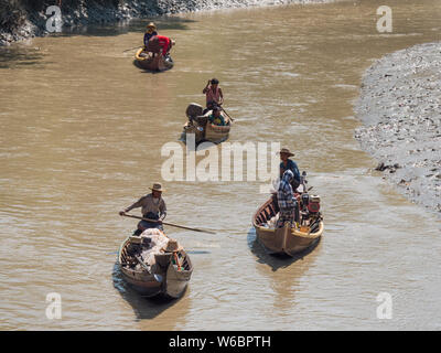 Dala, Myanmar - November 5, 2017: Small, traditional fishing vessels with husband and wife teams padling down Dala River near Yangon. Stock Photo
