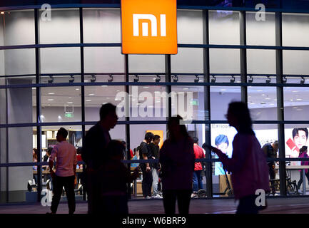 --FILE--Pedestrians walk past a Xiaomi store in Shenyang city, northeast China's Liaoning province, 13 May 2018.   The first Mi Store of Chinese techn Stock Photo