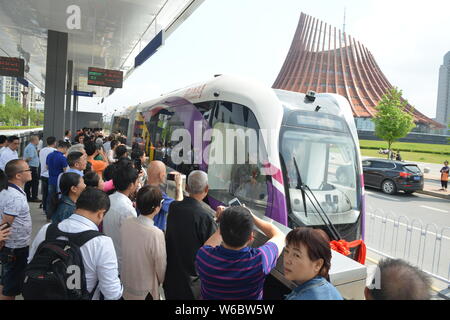 Passengers get on a railless train, developed by the CRRC Zhuzhou Institute Co. Ltd, on the world's first ART (Autonomous Rail Rapid Transit) A1 line Stock Photo