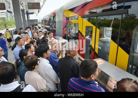 Passengers get on a railless train, developed by the CRRC Zhuzhou Institute Co. Ltd, on the world's first ART (Autonomous Rail Rapid Transit) A1 line Stock Photo