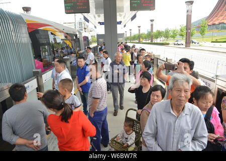 Passengers get on a railless train, developed by the CRRC Zhuzhou Institute Co. Ltd, on the world's first ART (Autonomous Rail Rapid Transit) A1 line Stock Photo