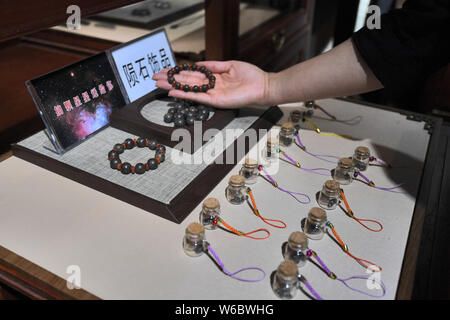 Chinese woman Yang Kexin of Miao ethnic group displays an artwork made of aerolite at her science museum to introduce meteorite culture in Guiyang cit Stock Photo