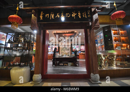 Chinese woman Yang Kexin of Miao ethnic group introduces an artwork made of aerolite to customers at her science museum to introduce meteorite culture Stock Photo