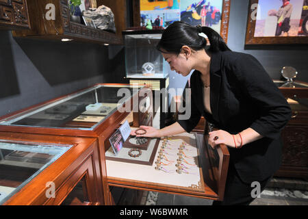 Chinese woman Yang Kexin of Miao ethnic group displays an artwork made of aerolite at her science museum to introduce meteorite culture in Guiyang cit Stock Photo