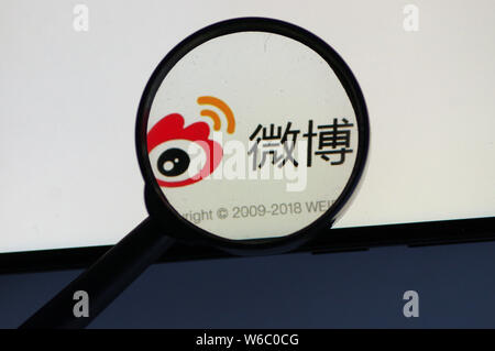 --FILE--A Chinese netizen looks at a logo of Weibo, the Twitter-like microblogging service of Chinese Internet portal Sina, on his smartphone in Ji'na Stock Photo